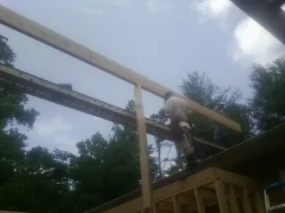 Carpenter setting a ridge beam over a new addition frame — Ice Dam Removal by Roofing Brothers in Glen Alpine