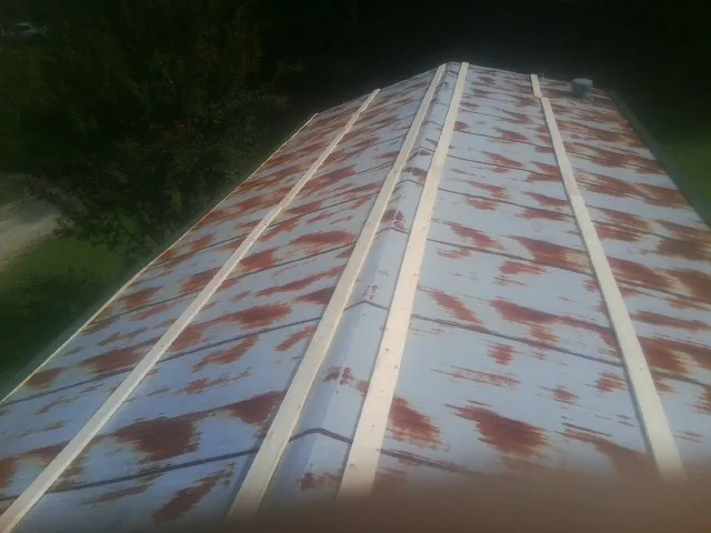 Rusted metal roof panels with new wood purlins before replacement — Storm Damage Roof Repair in Glen Alpine by Roofing Brothers