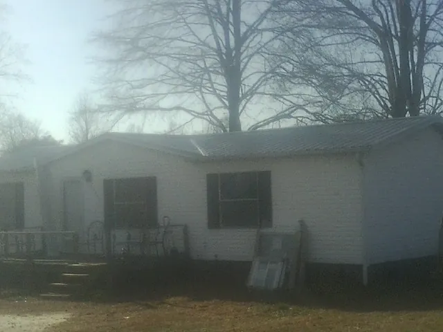 New metal roof on a white painted brick home on a foggy morning in Glen Alpine