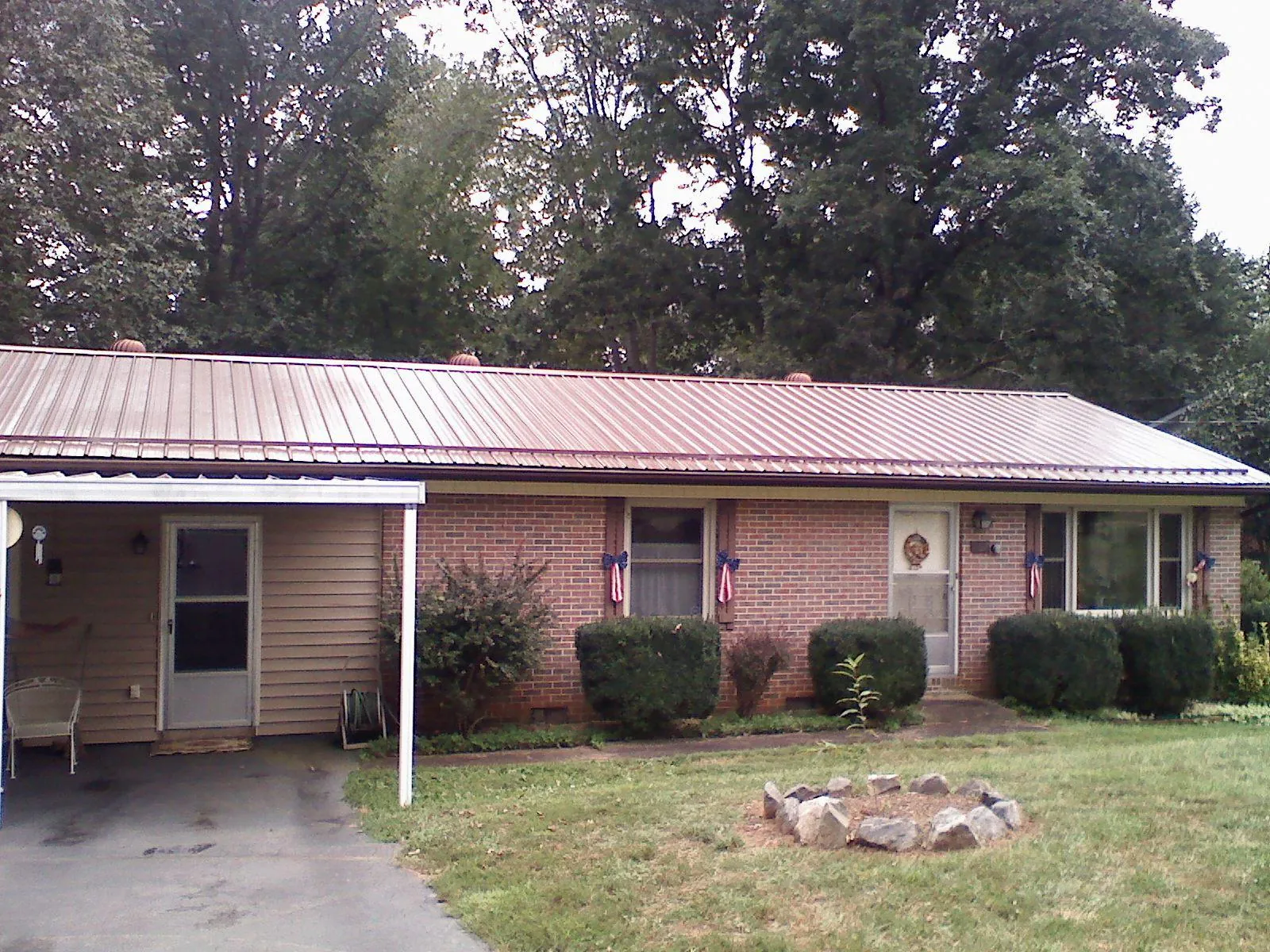 Bronze metal roof and carport on a brick ranch home — Roof Repair work by our crew in Glen Alpine